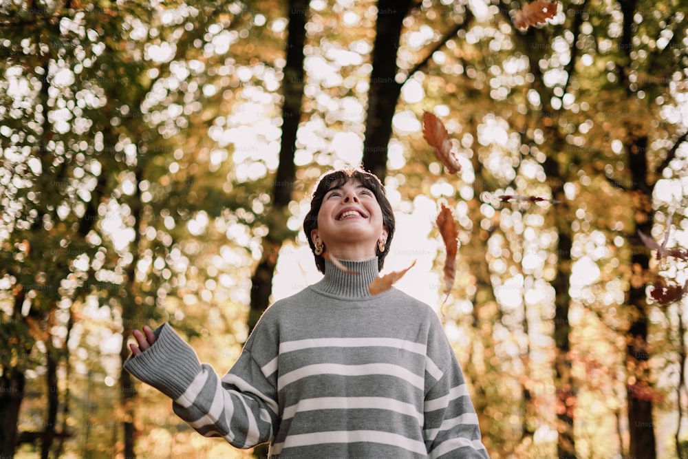 a woman standing in a forest with her arms outstretched