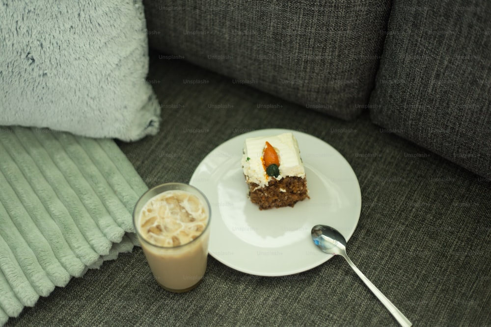 un plato blanco cubierto con un pedazo de pastel junto a una taza de café