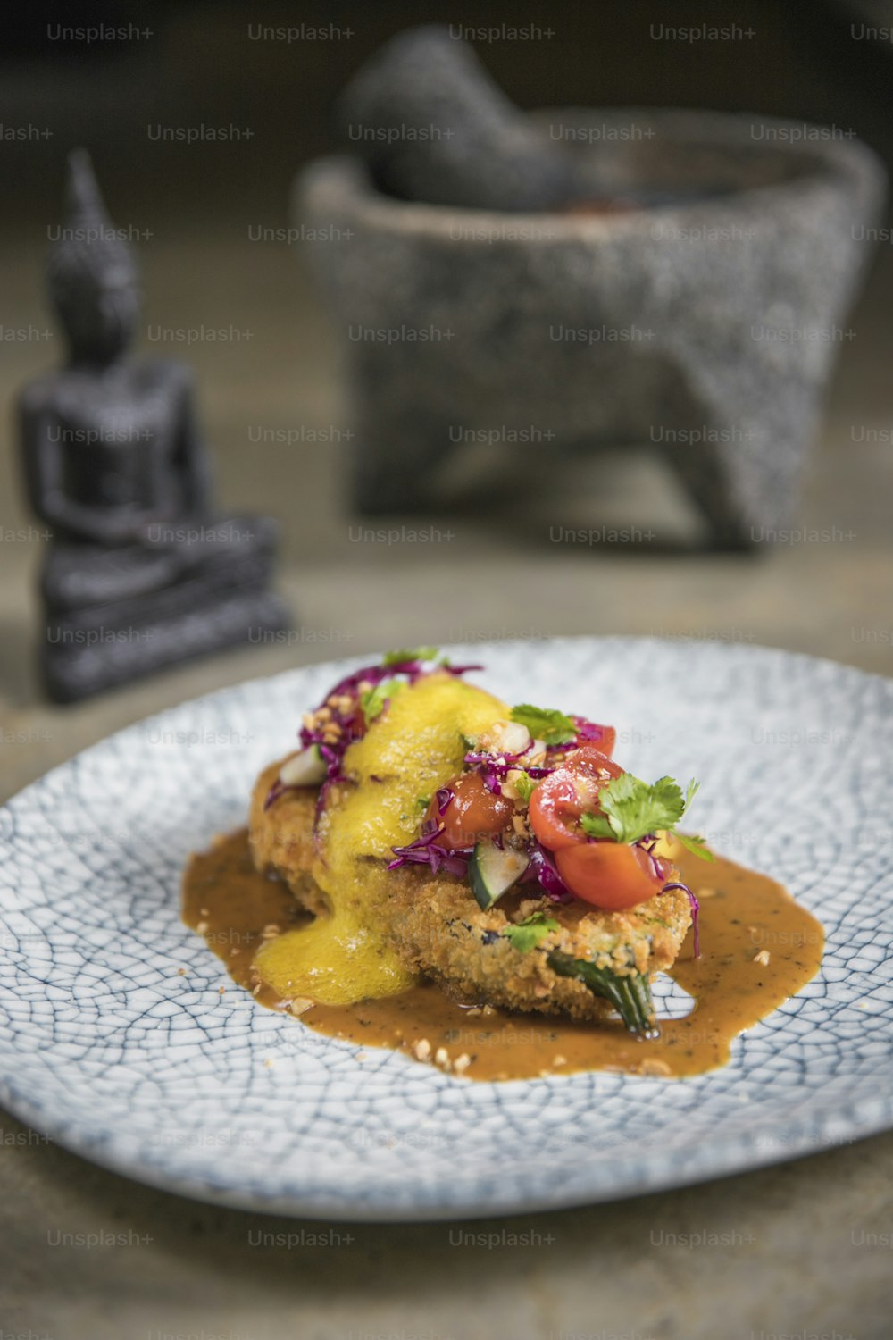 Um prato de comida com uma estátua de Buda ao fundo