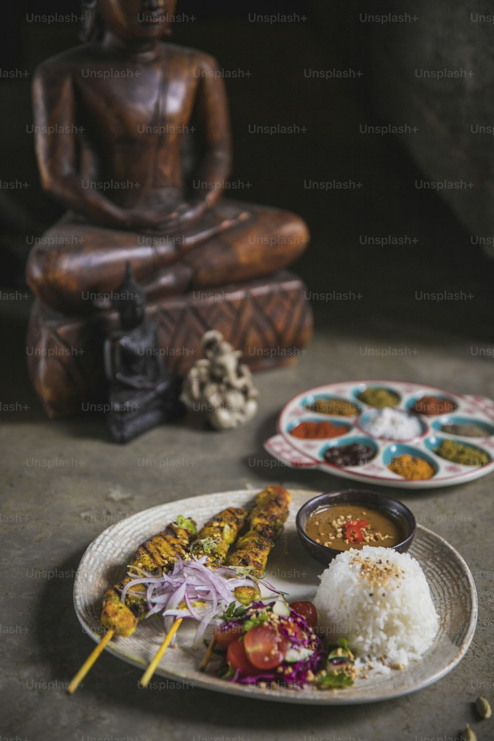 Um prato de comida com uma estátua de Buda ao fundo