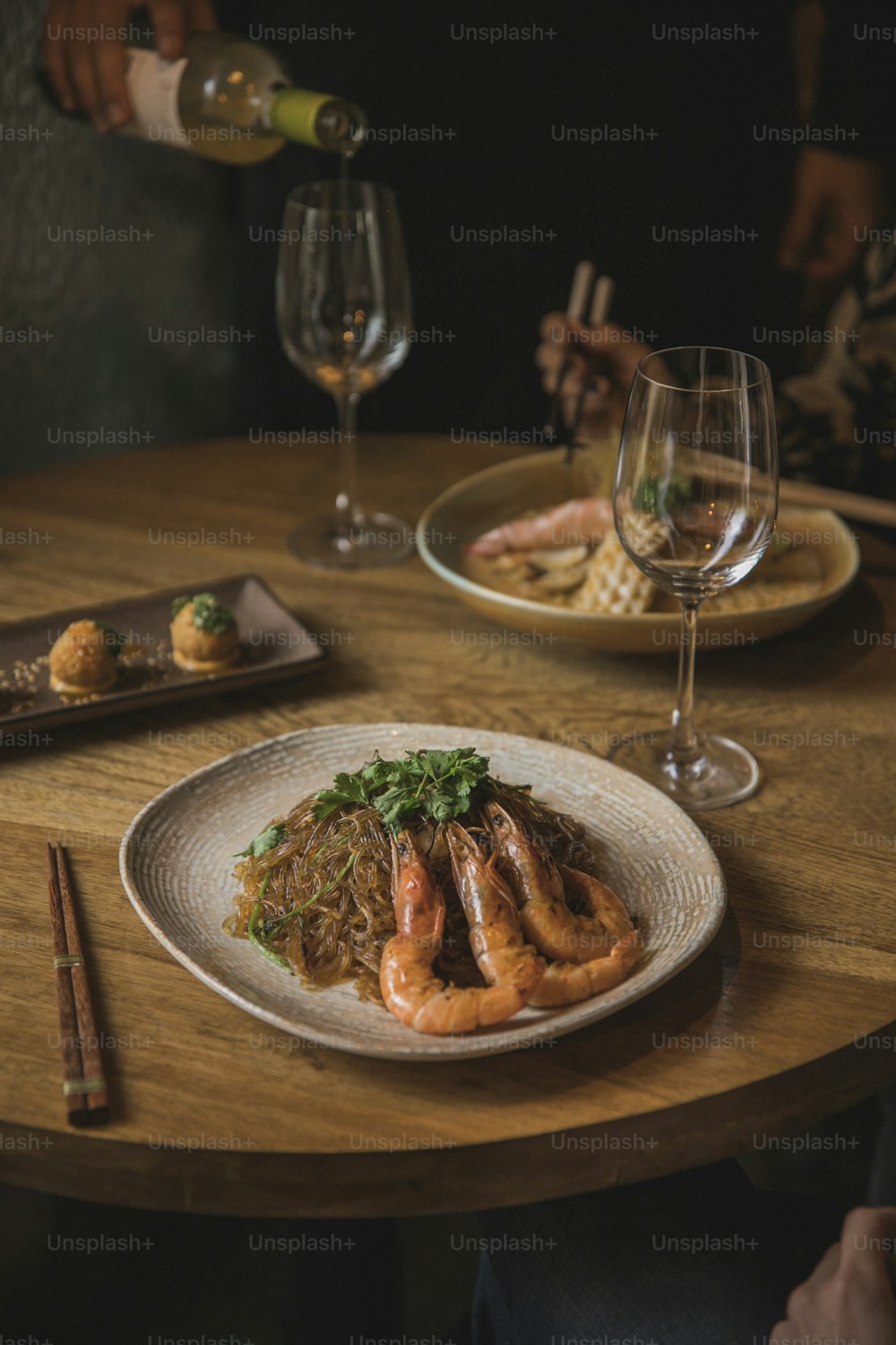 a table with a plate of food and a glass of wine