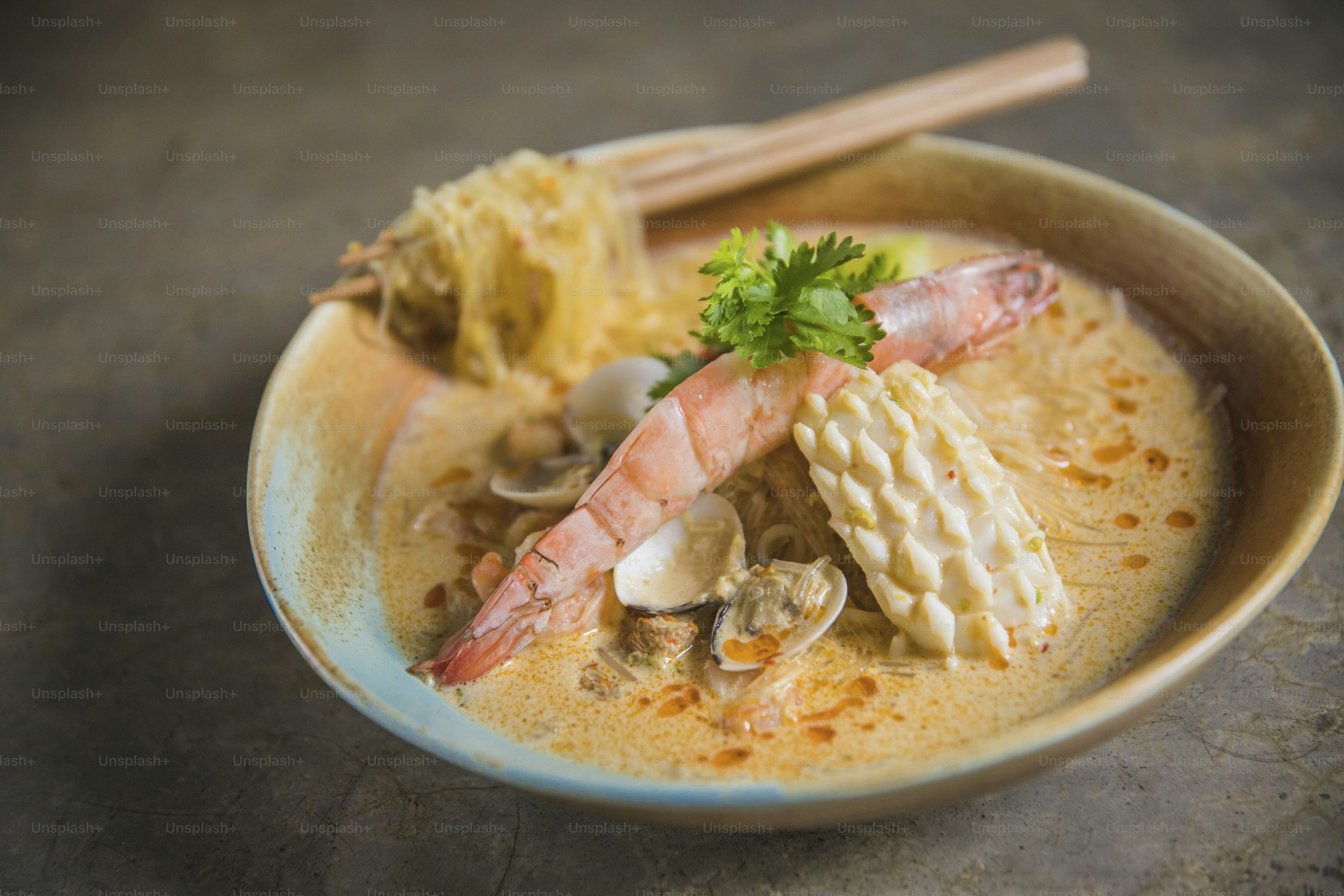 a bowl of soup with shrimp, shrimp, and noodles
