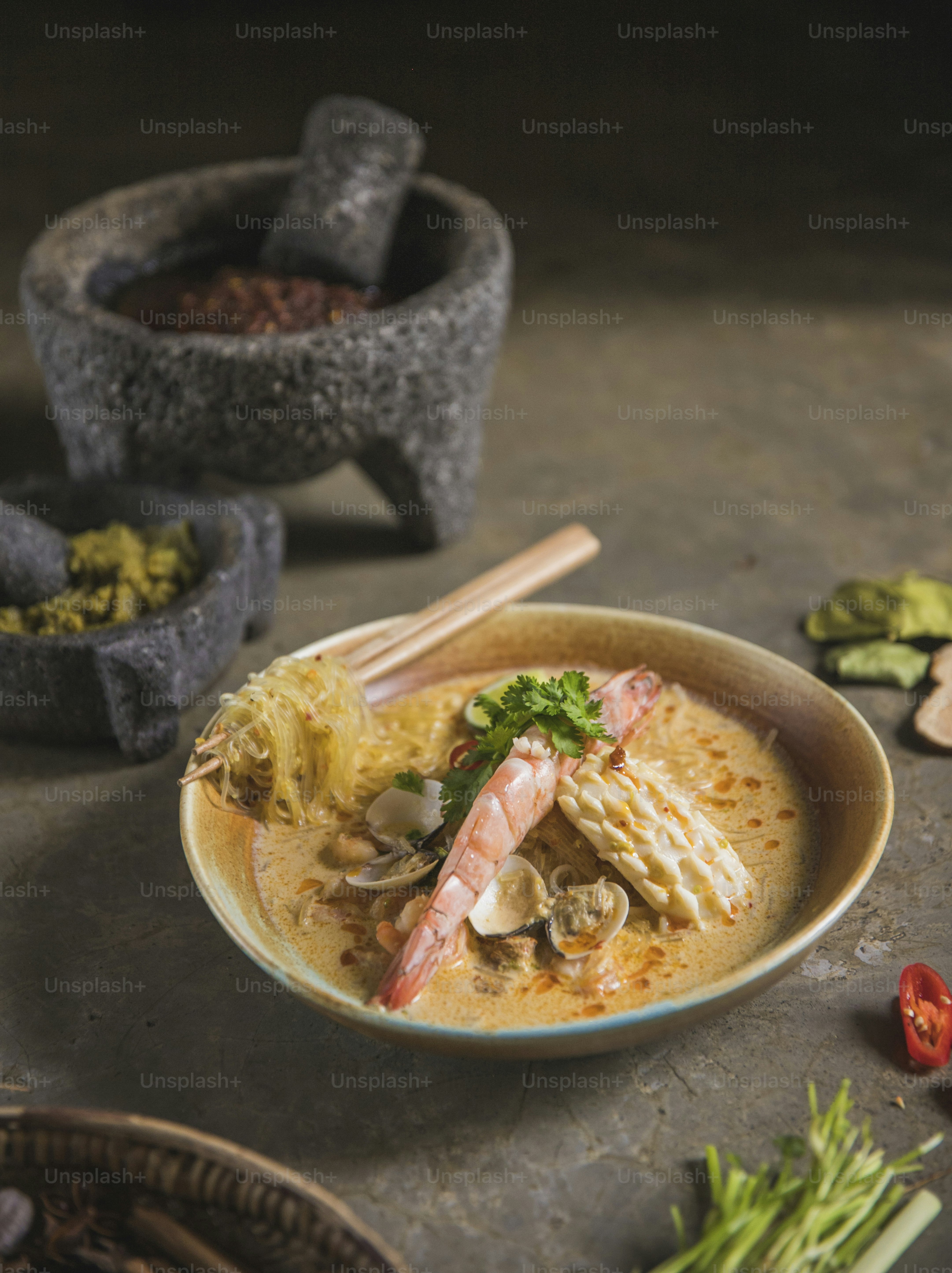 a bowl of soup with shrimp, mushrooms and broccoli