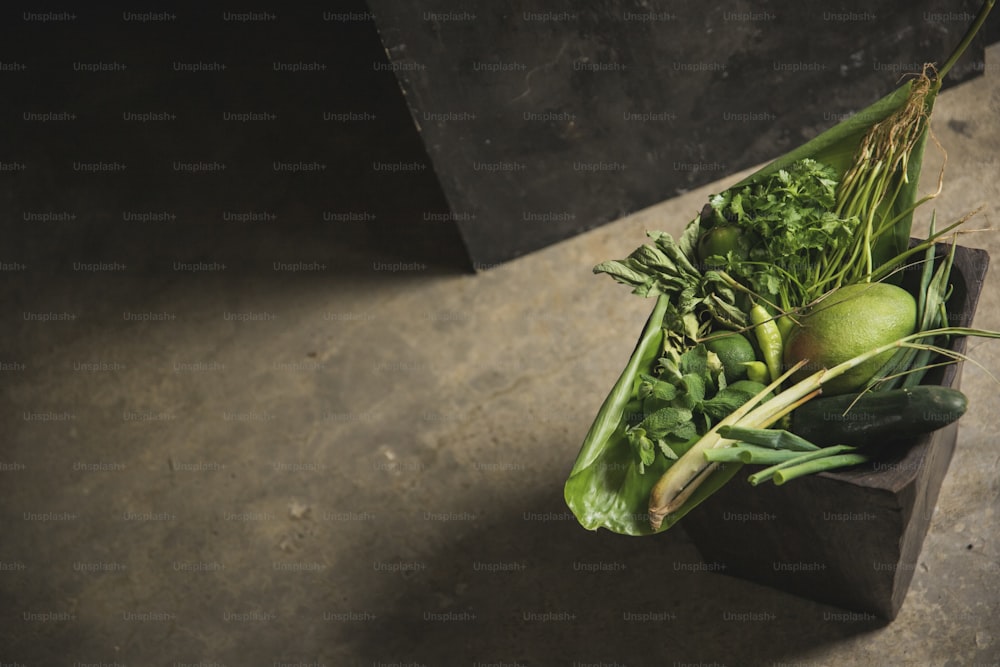 a wooden box filled with lots of green vegetables