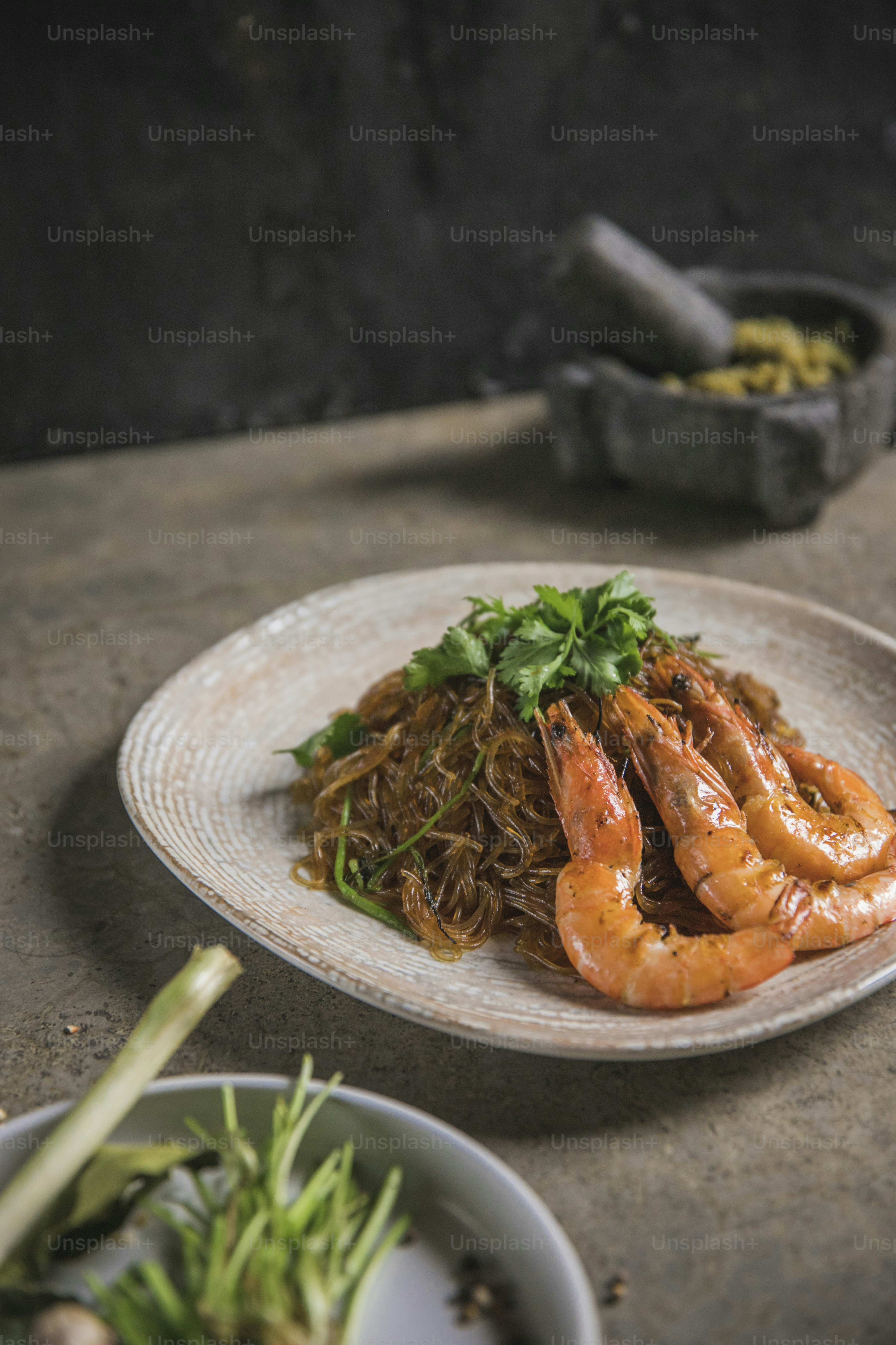 a plate of shrimp and noodles on a table