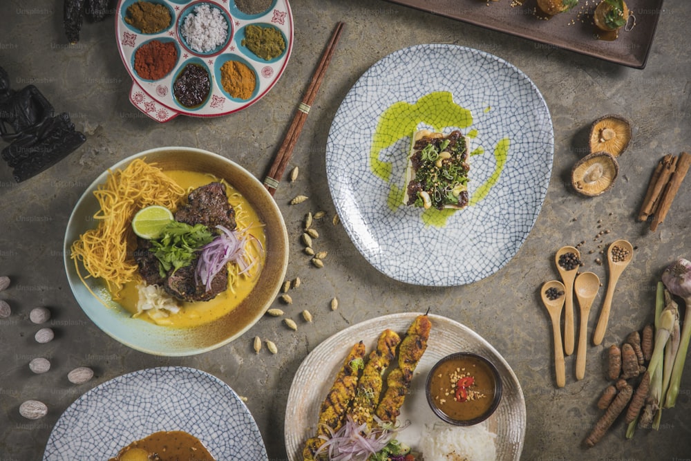 a table topped with plates of food and utensils