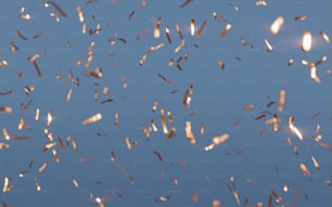 a group of birds flying through a blue sky