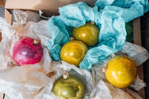 a box filled with different colored ornaments on top of a table