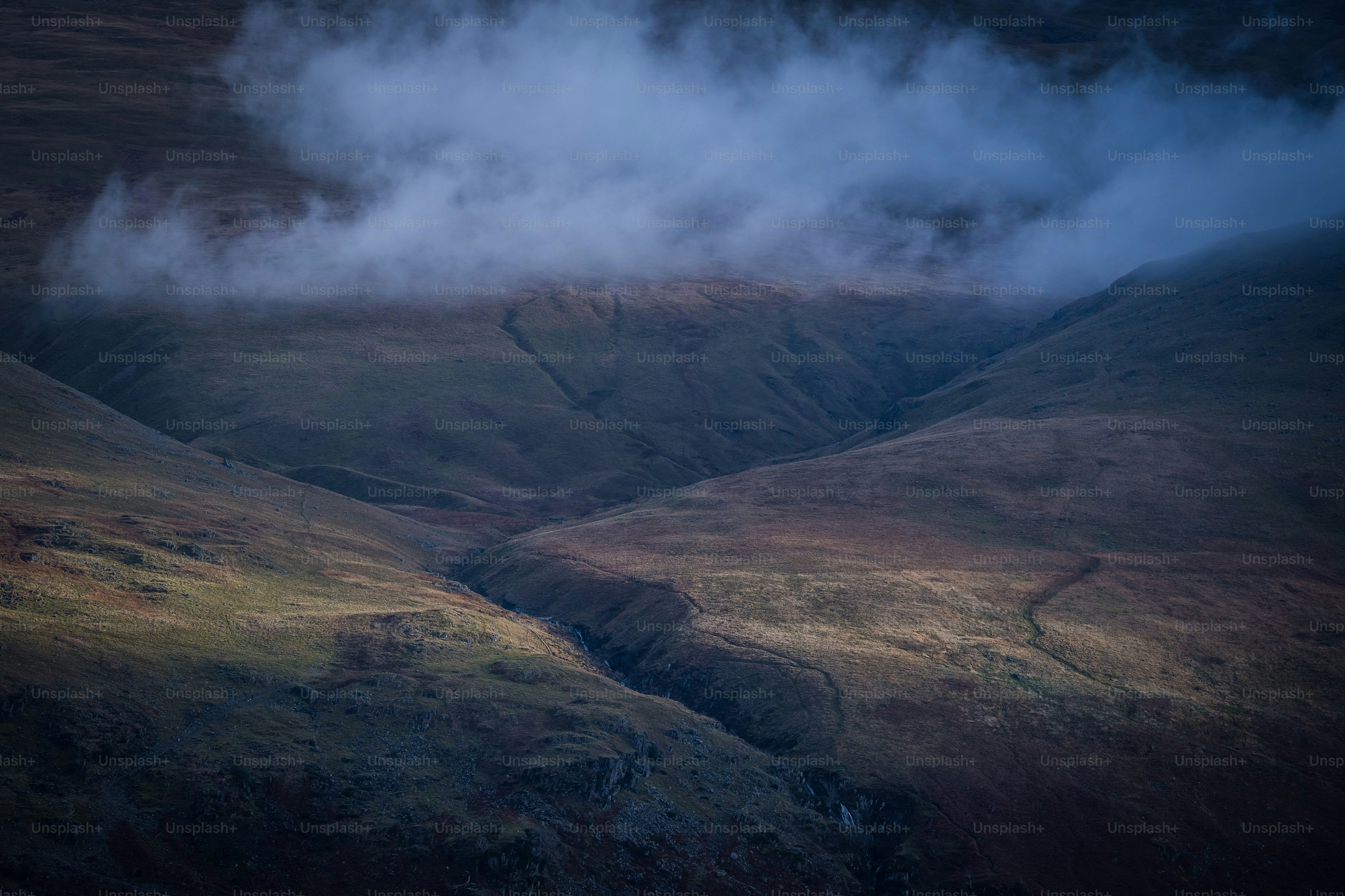 a view of a mountain range with clouds in the sky