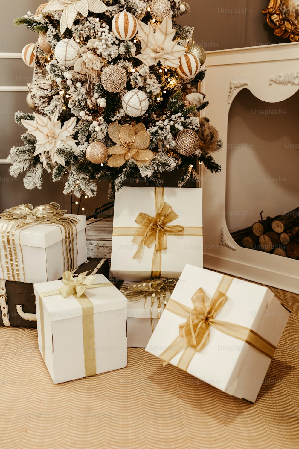 ein Weihnachtsbaum mit Geschenken darunter neben einem Kamin