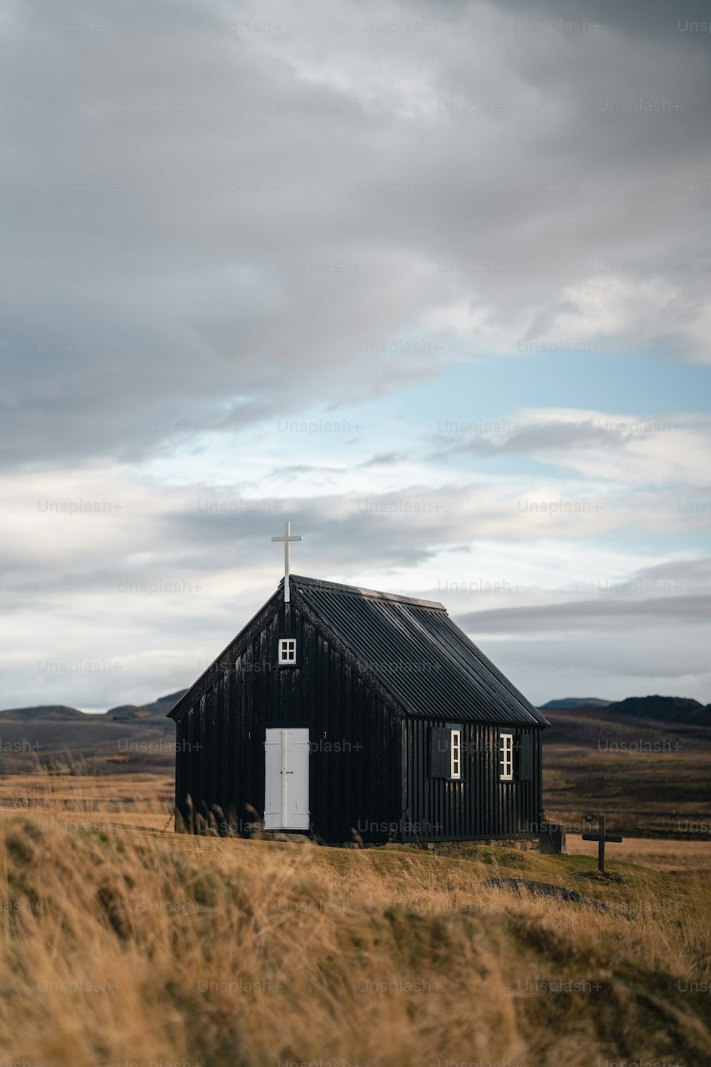 a black building with a cross on the top of it