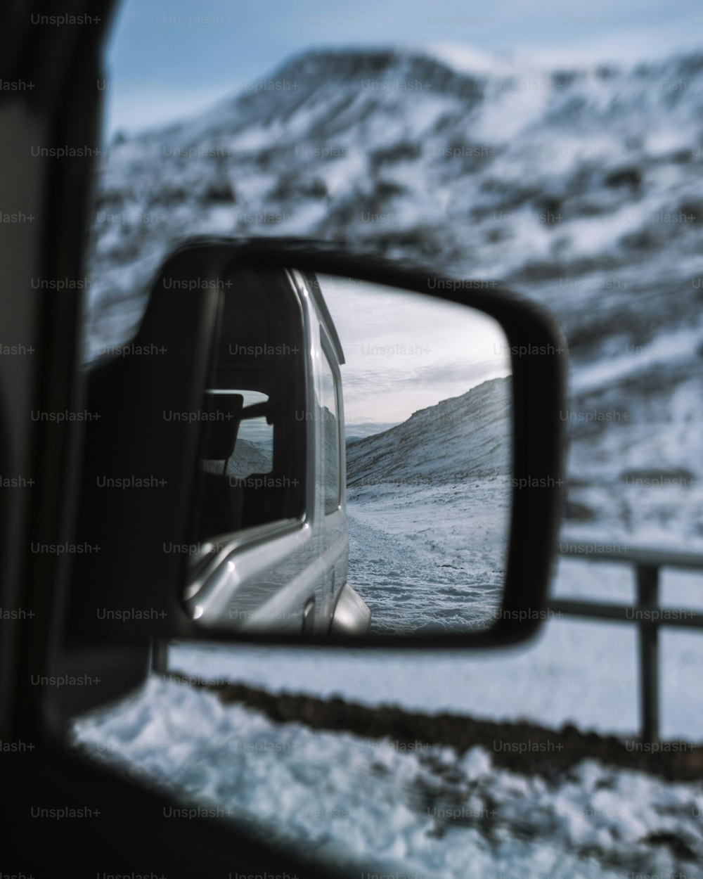 Der Seitenspiegel eines Autos mit einem Berg im Hintergrund