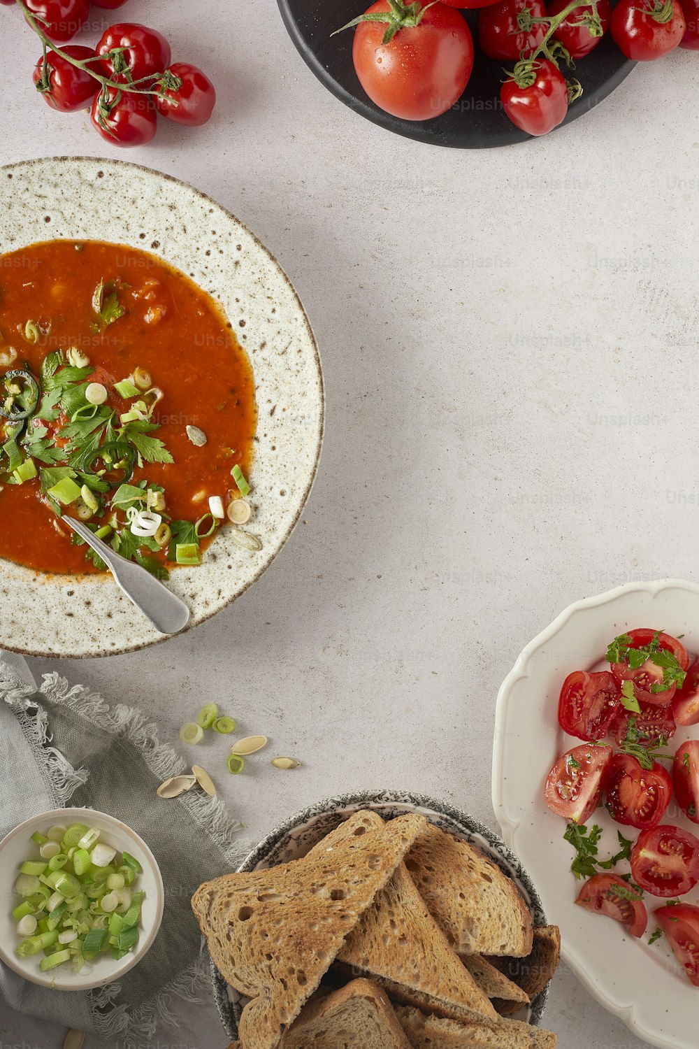 a table topped with bowls of soup and a plate of chips