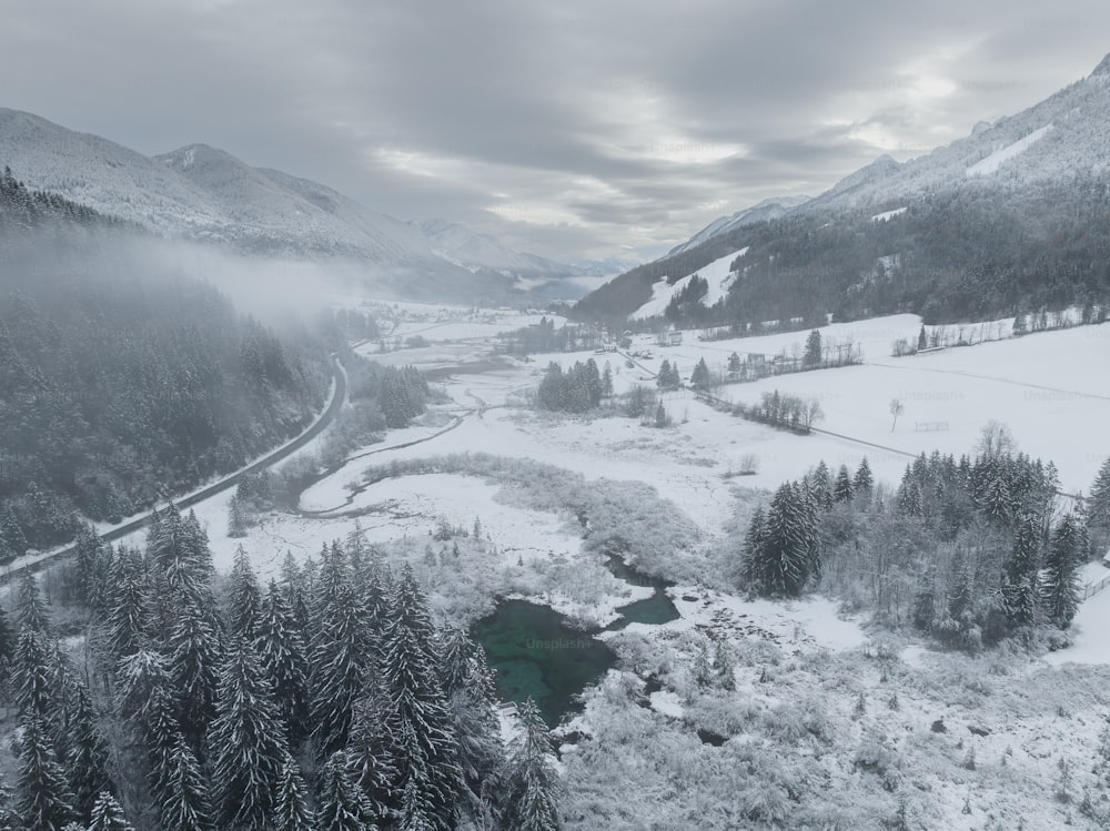 Un valle cubierto de nieve con un río rodeado de árboles