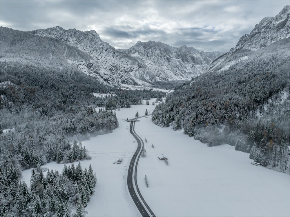a winding road surrounded by snow covered mountains