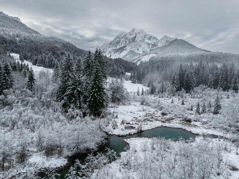 a snow covered mountain range with a river in the foreground
