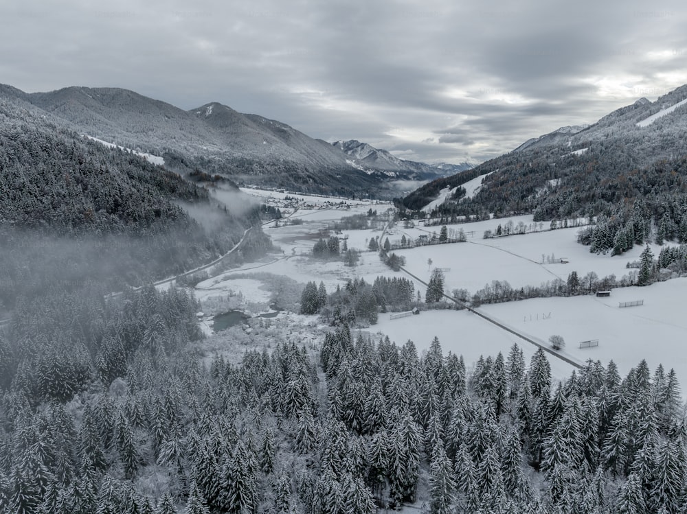 a snow covered valley surrounded by mountains and trees