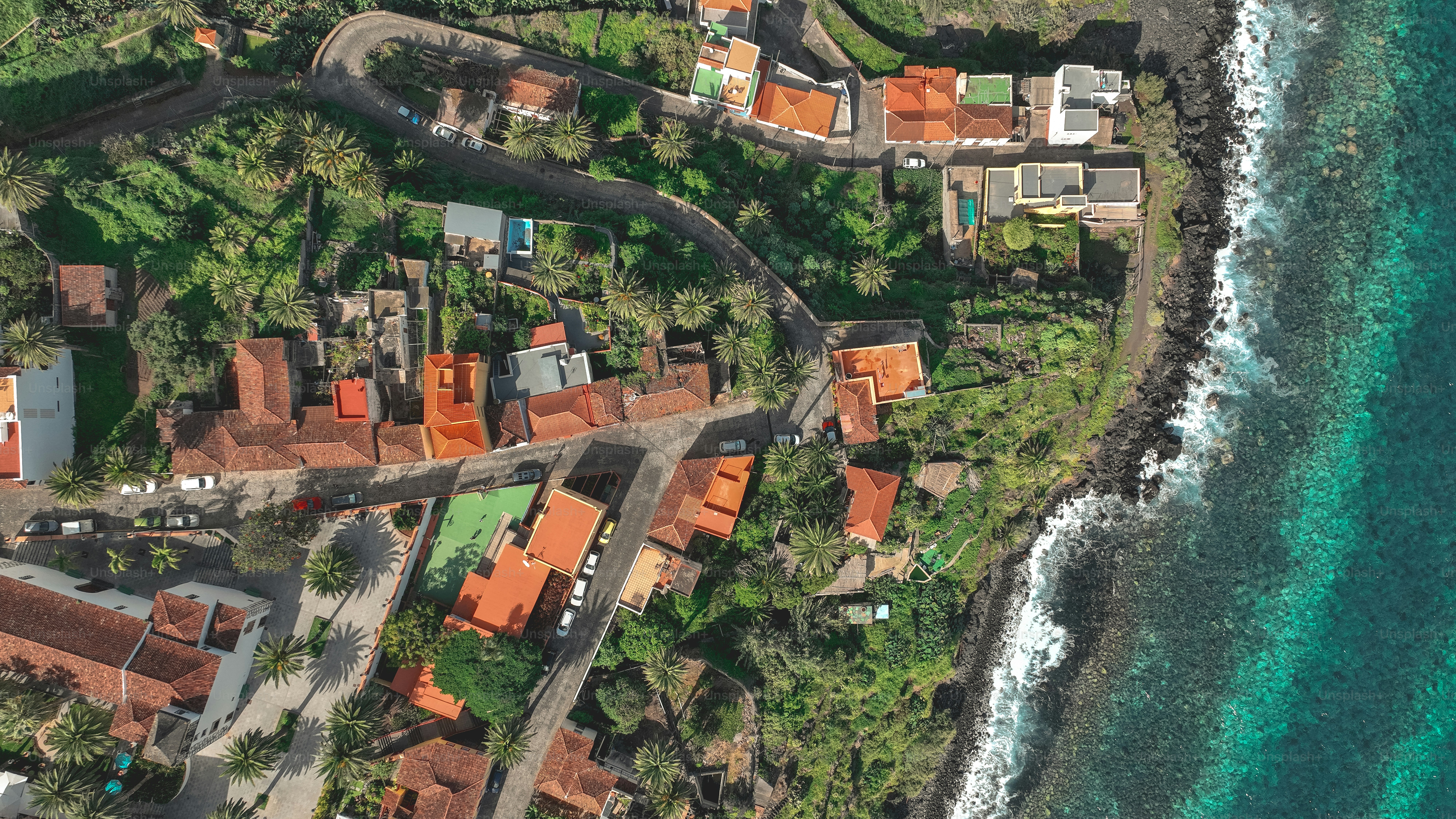 an aerial view of a small village by the ocean