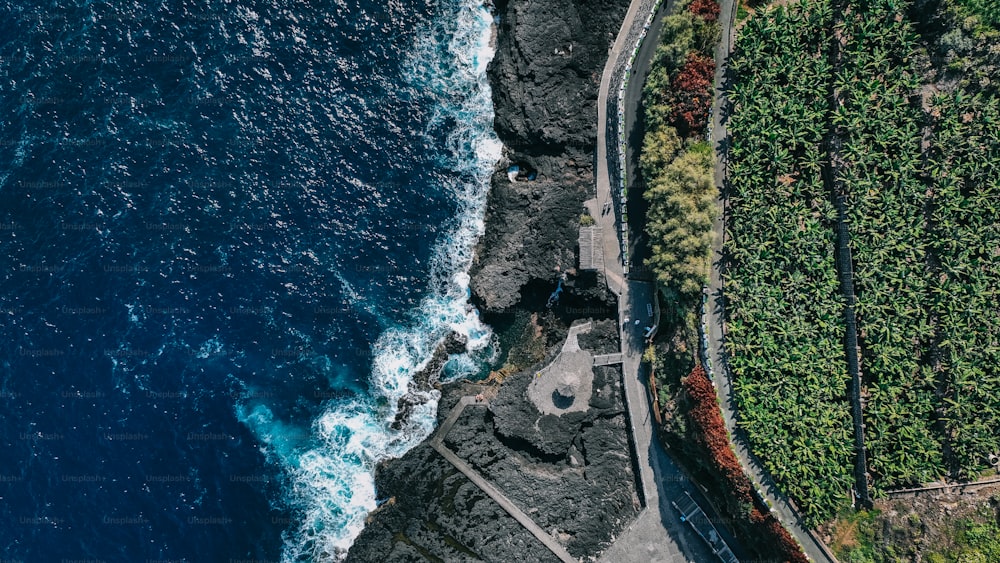 an aerial view of a road next to the ocean