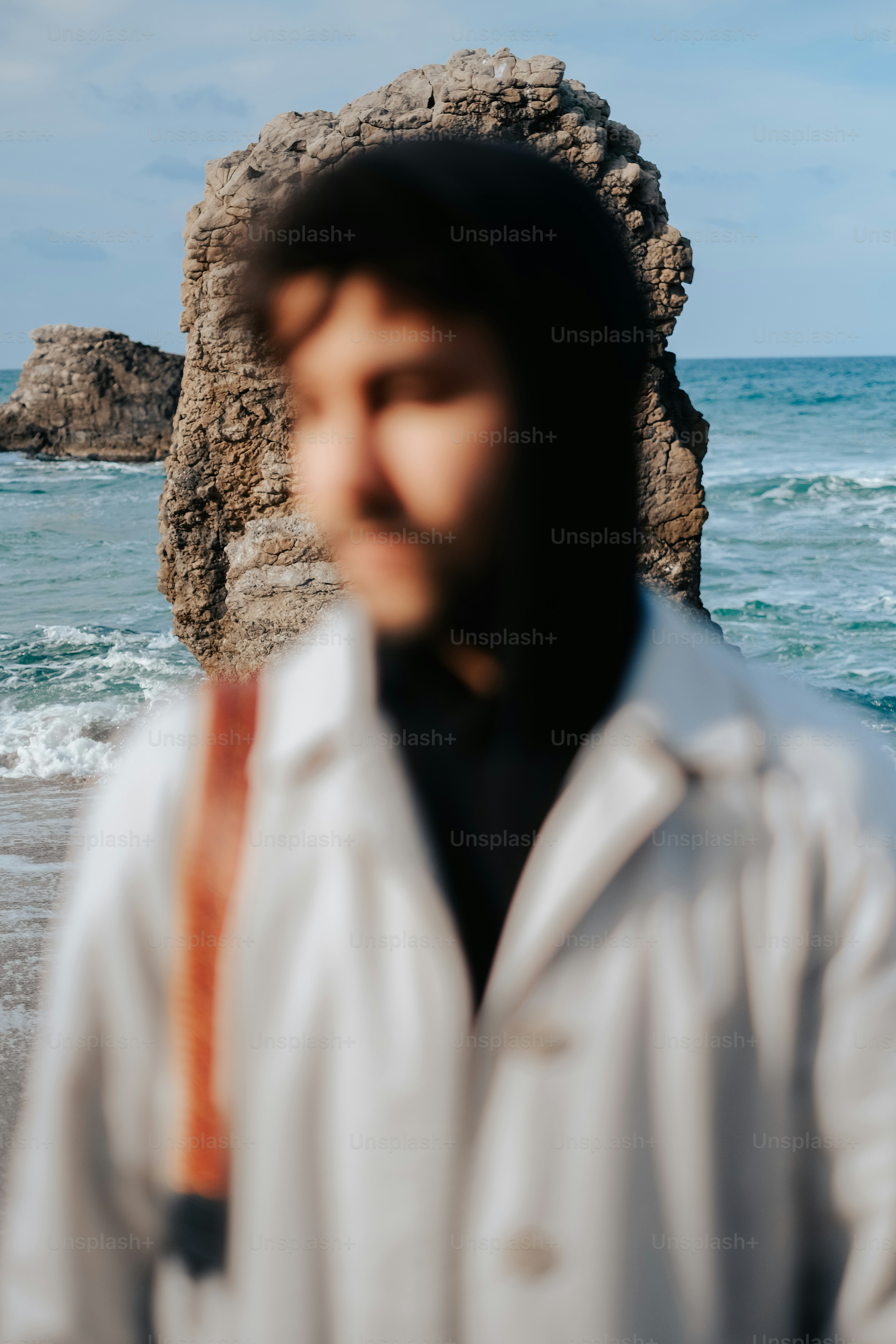Ein Mann, der an einem Strand neben dem Meer steht