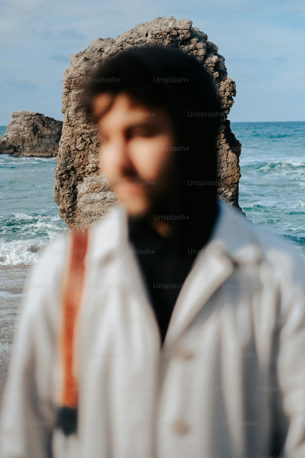 um homem de pé em uma praia ao lado do oceano