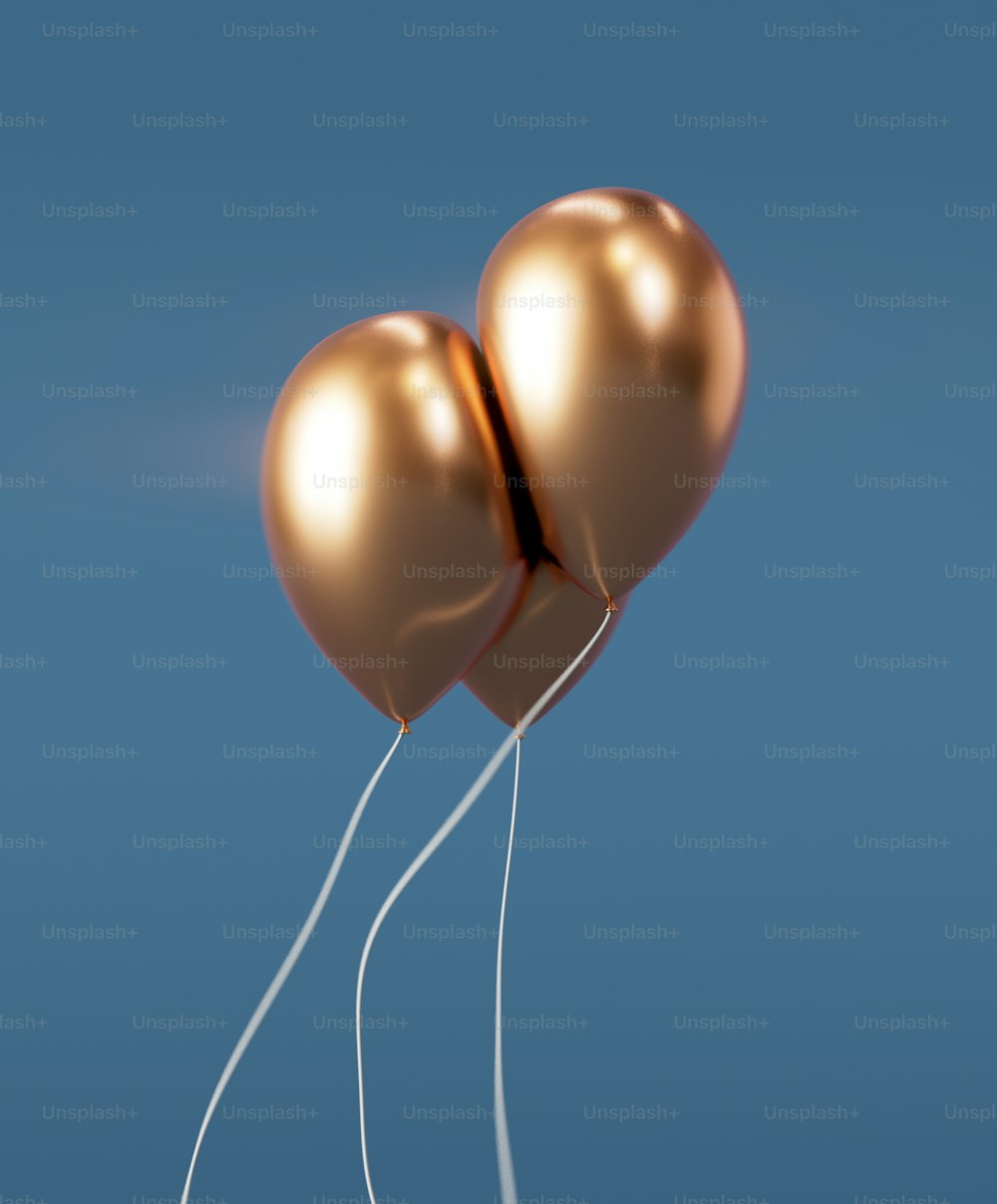 a couple of gold balloons floating in the air