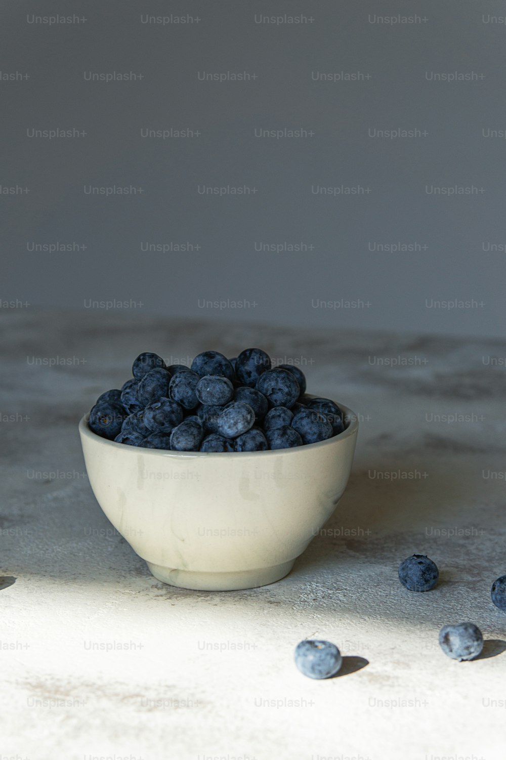 테이블 위에 블루베리로 채워진 하얀 그릇