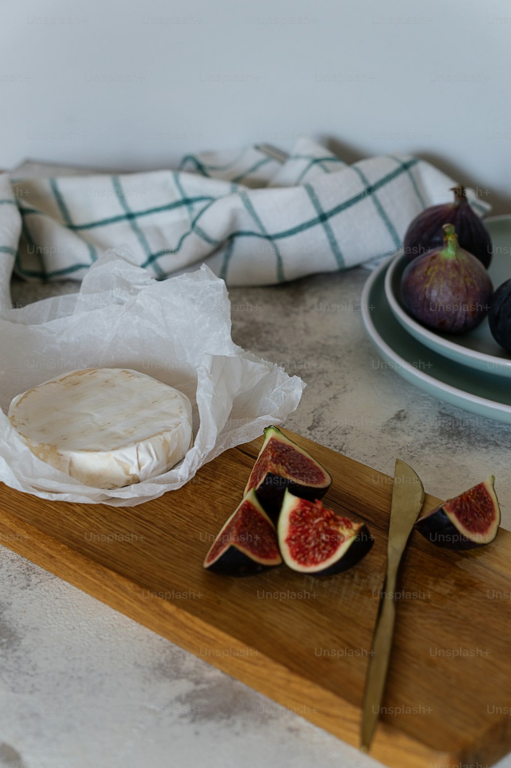 a wooden cutting board topped with sliced figs and cheese