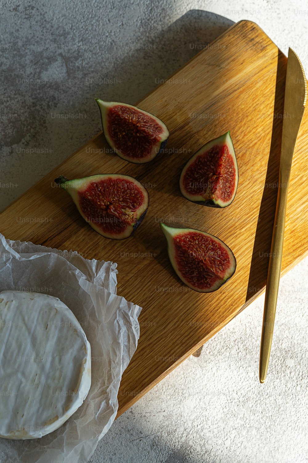 a wooden cutting board topped with sliced up figs