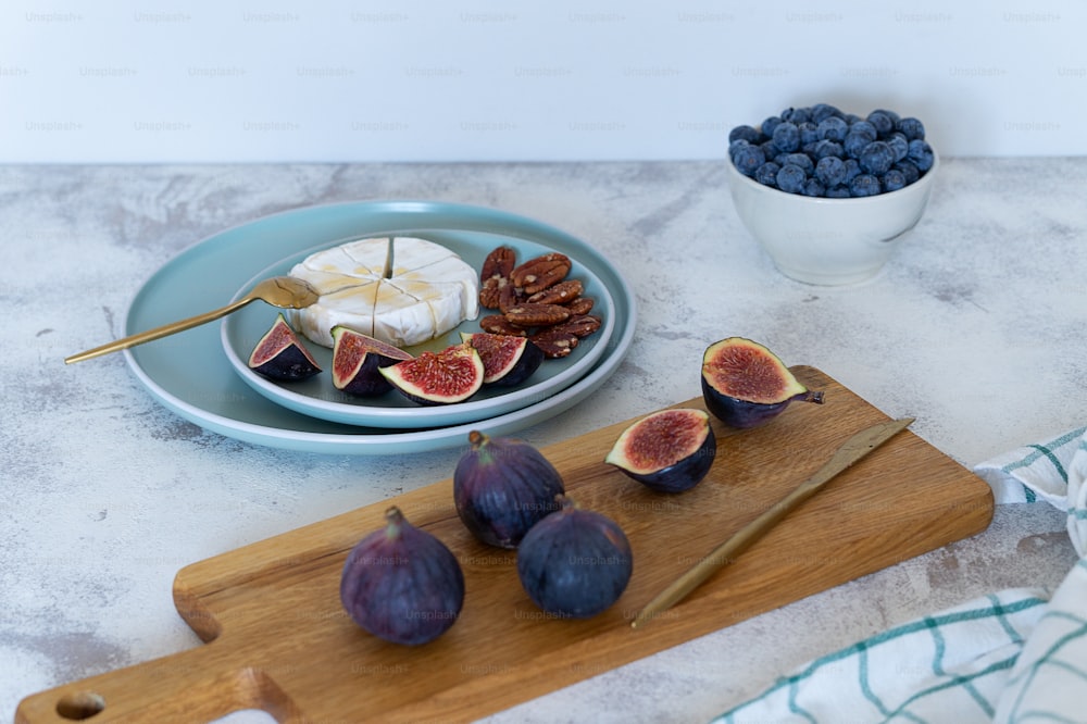 figs, cheese, and blueberries on a cutting board