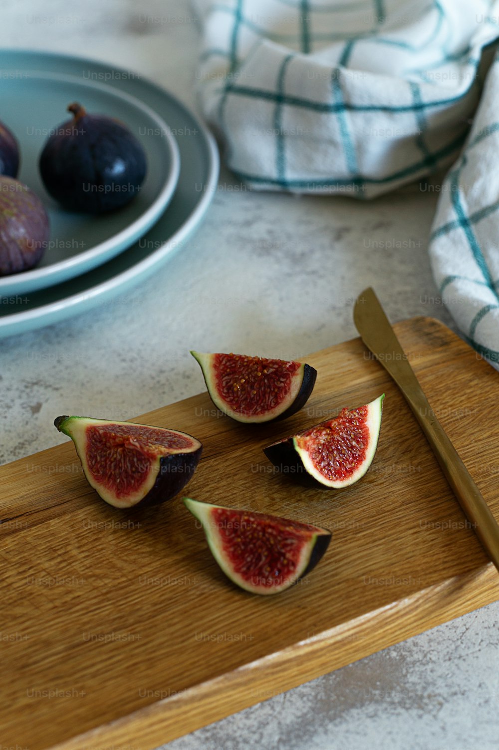a wooden cutting board topped with sliced figs