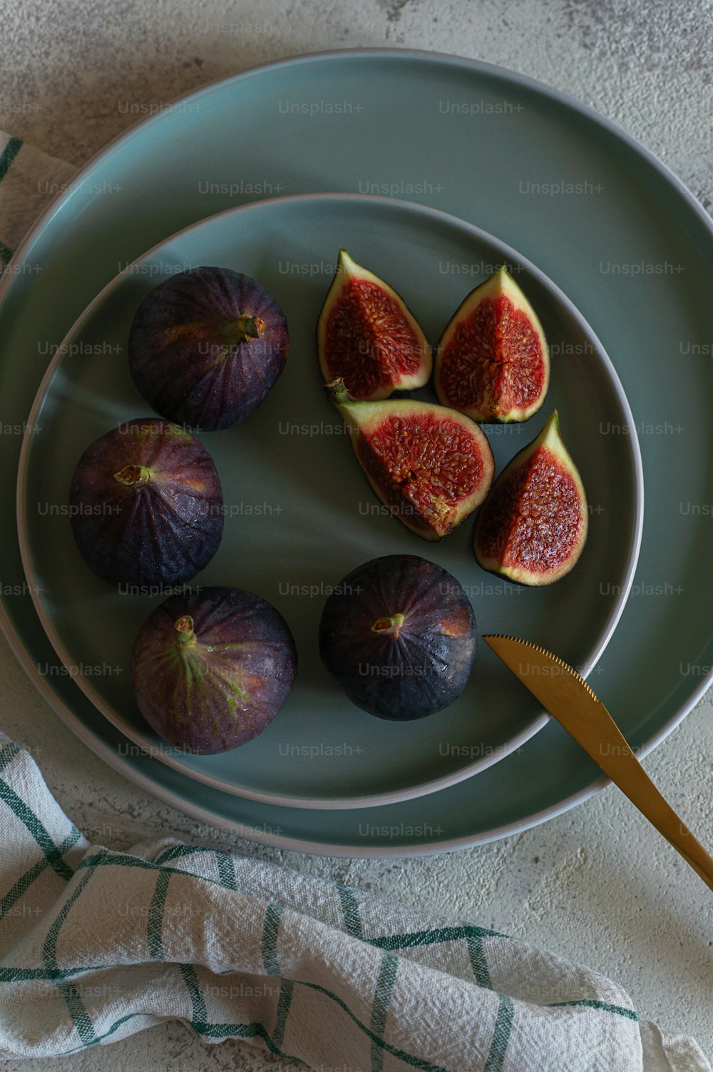 a plate of figs and a knife on a table