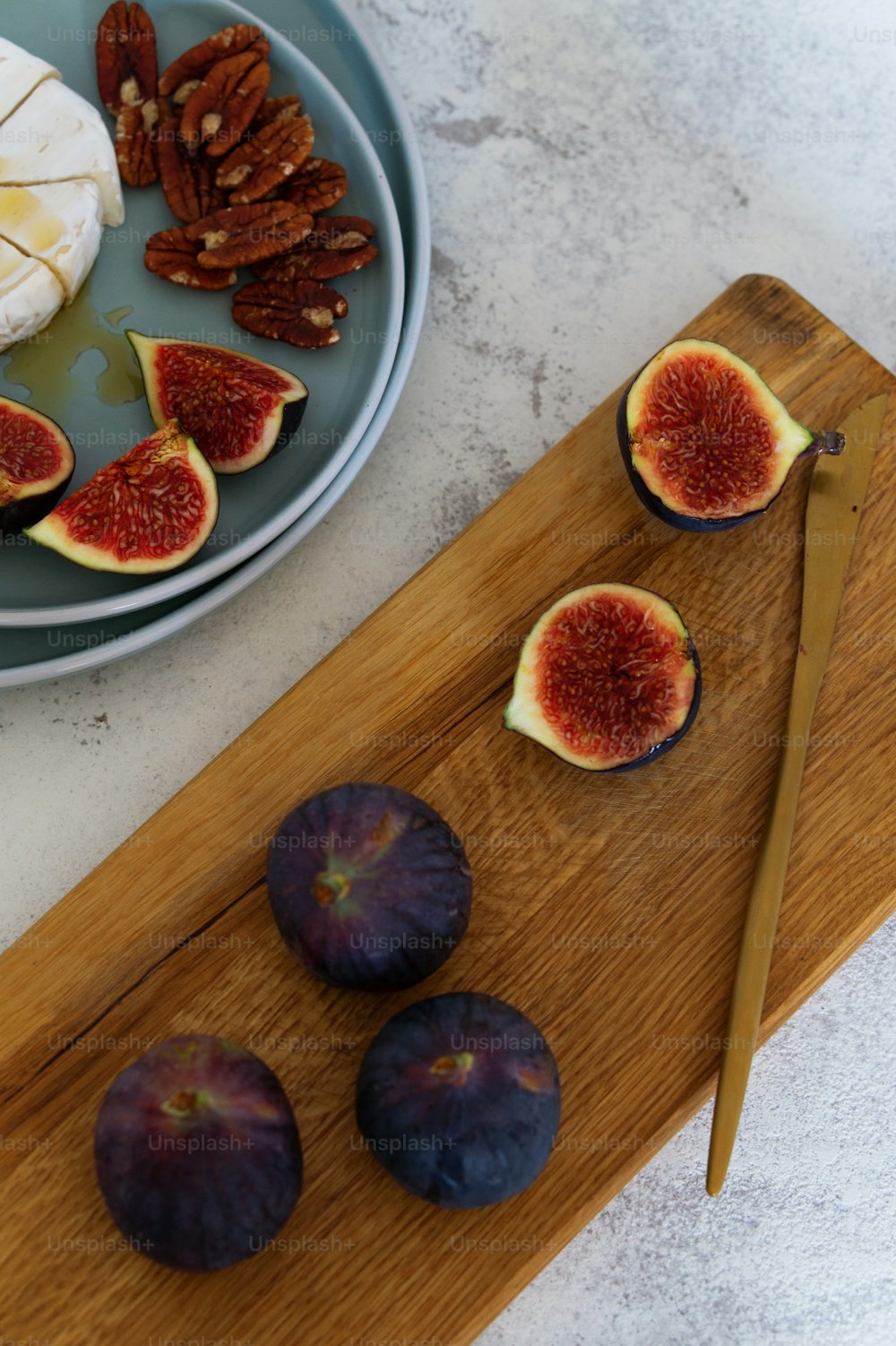 a cutting board topped with sliced figs next to a knife