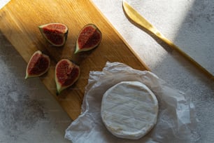 a wooden cutting board topped with a piece of cheese