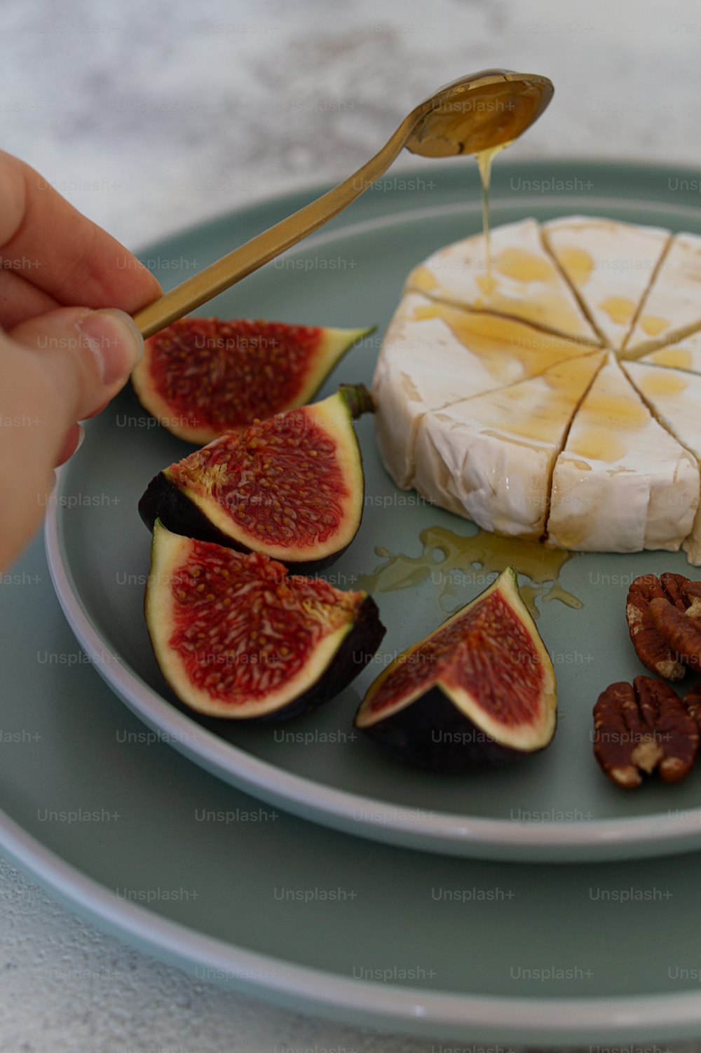 a plate with figs, cheese and nuts on it