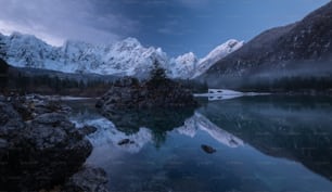 Uno specchio d'acqua circondato da montagne sotto un cielo nuvoloso