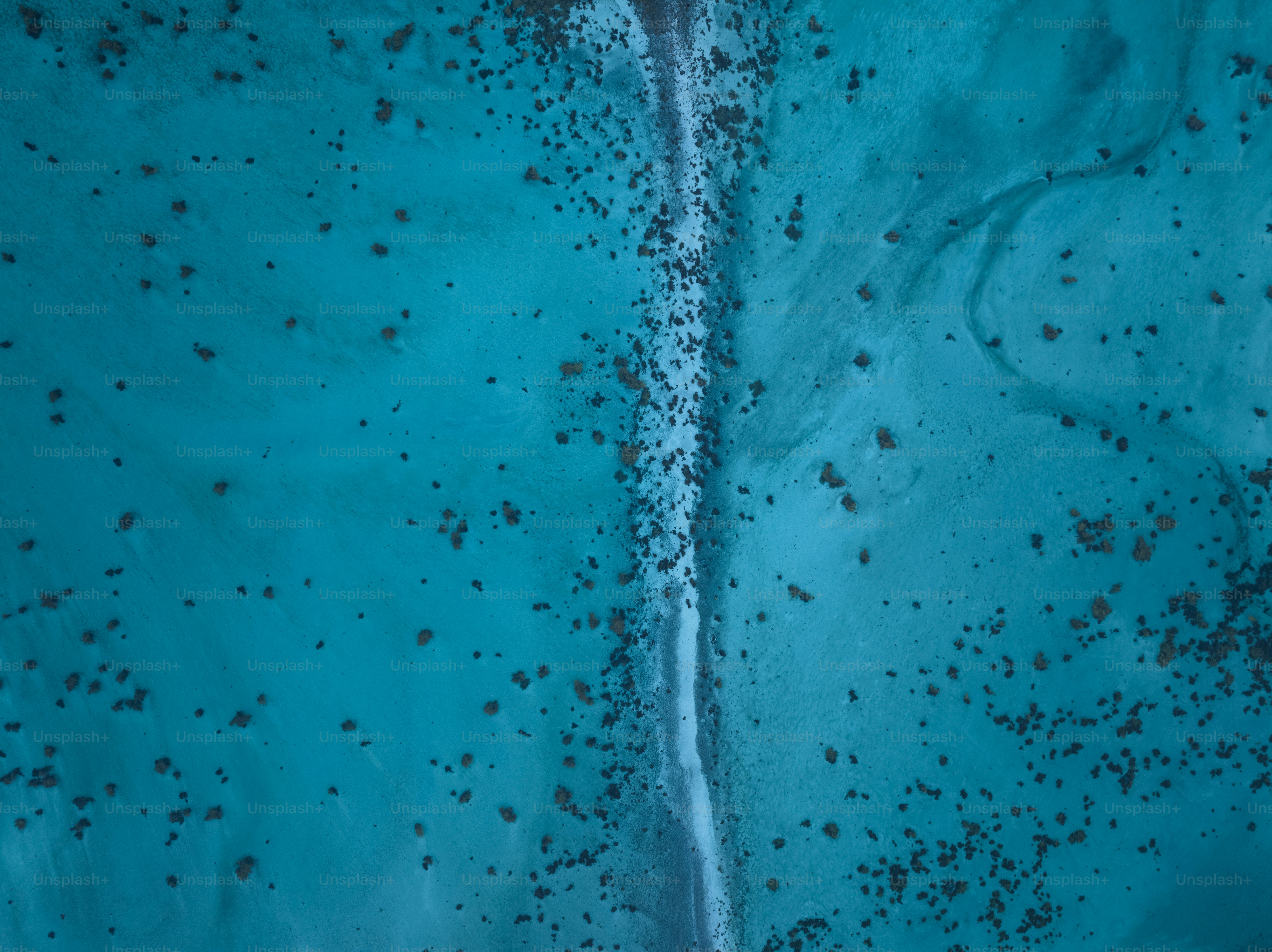 an aerial view of a beach with blue water