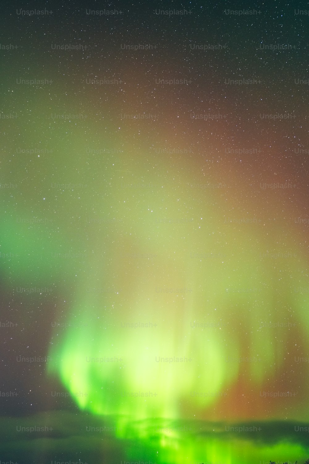 a bright green and red aurora bore above the clouds