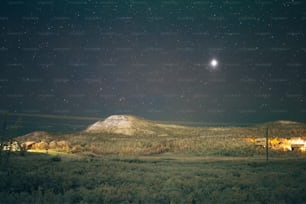 the night sky with stars above a mountain