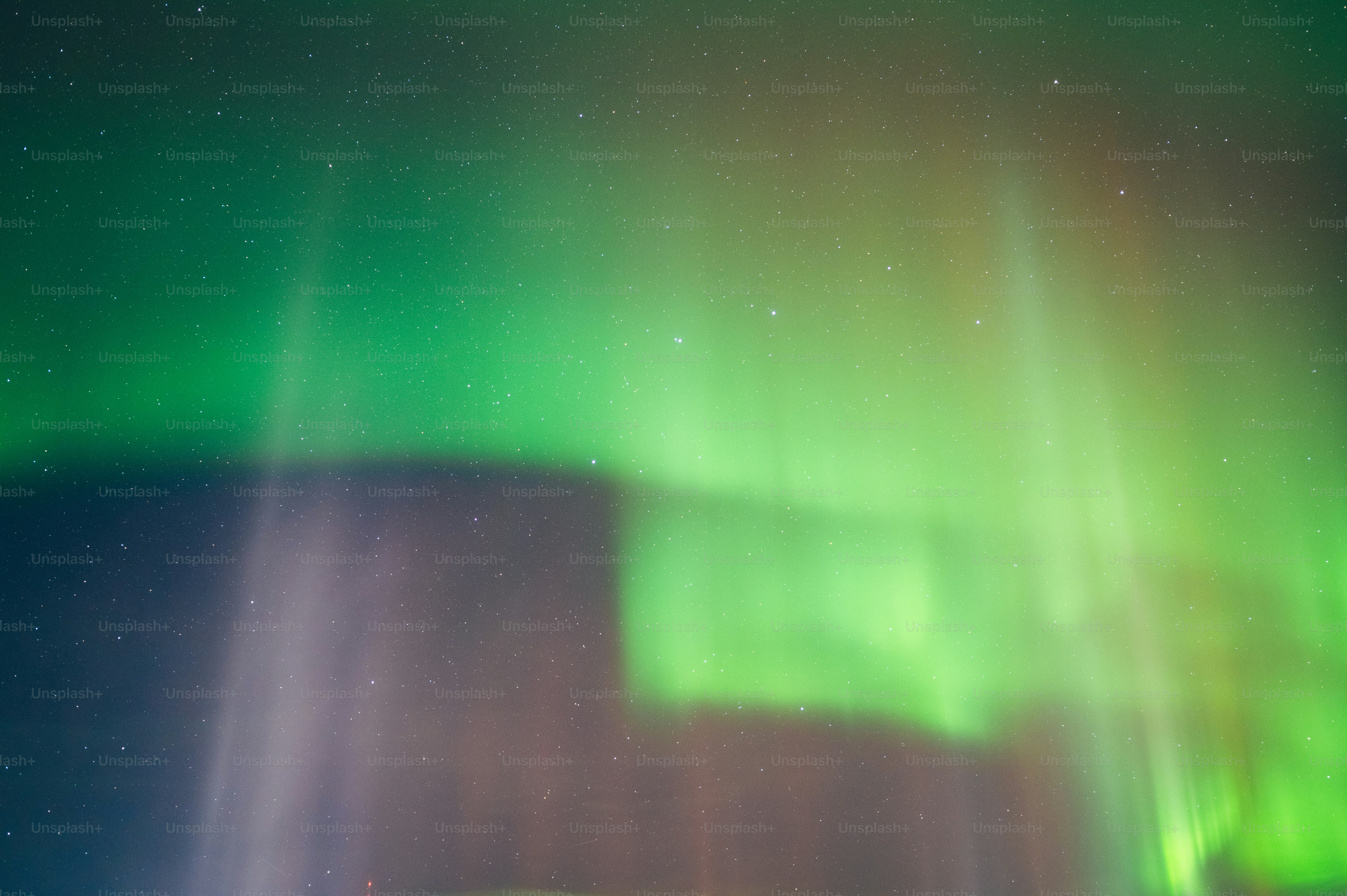 a green and white aurora bore is in the sky