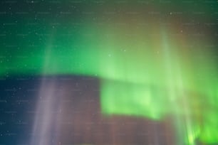 a green and white aurora bore is in the sky