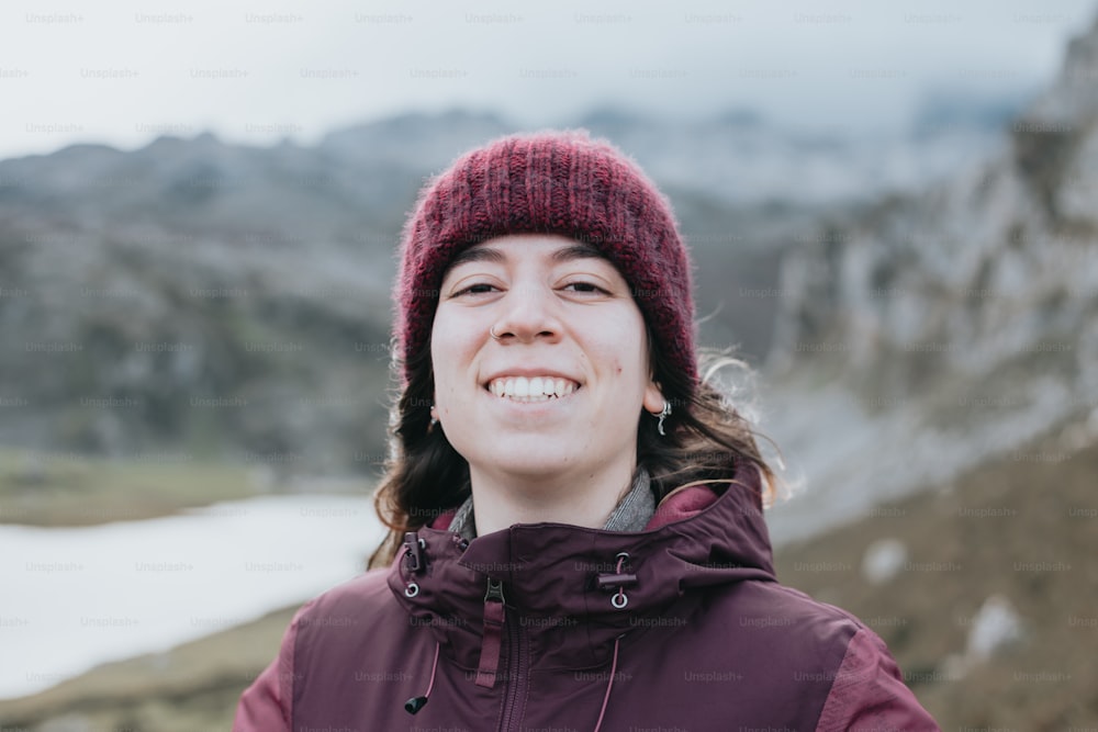 a woman wearing a purple jacket and a maroon hat