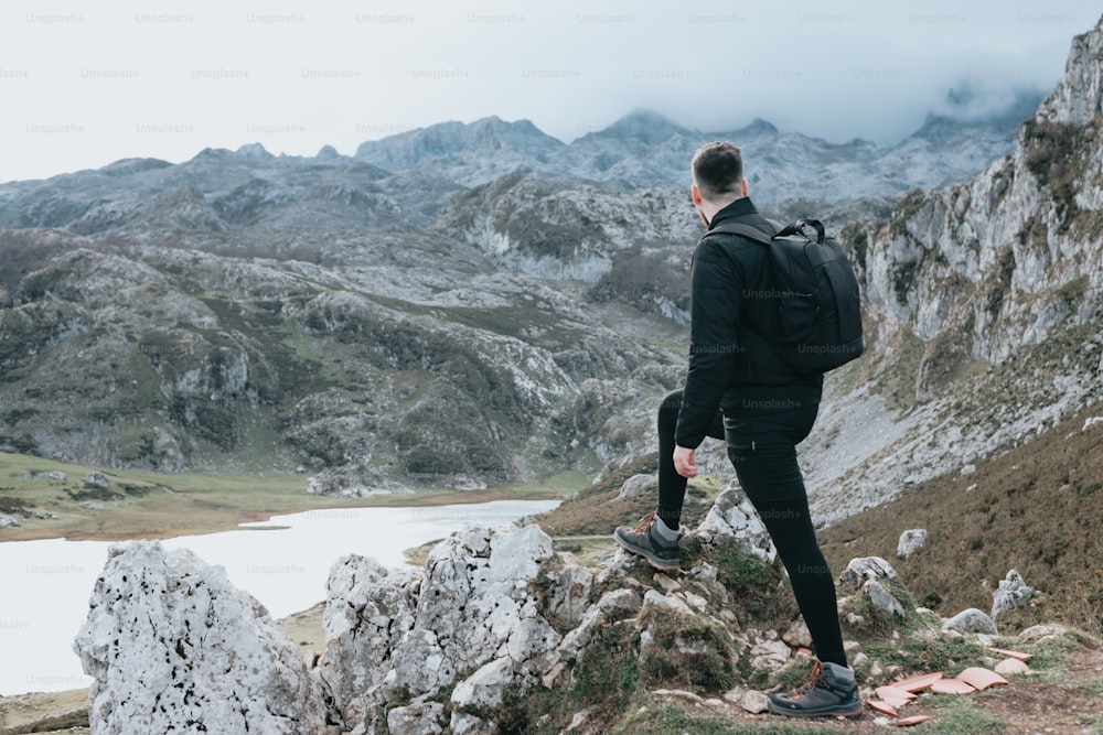 a man with a backpack standing on a mountain