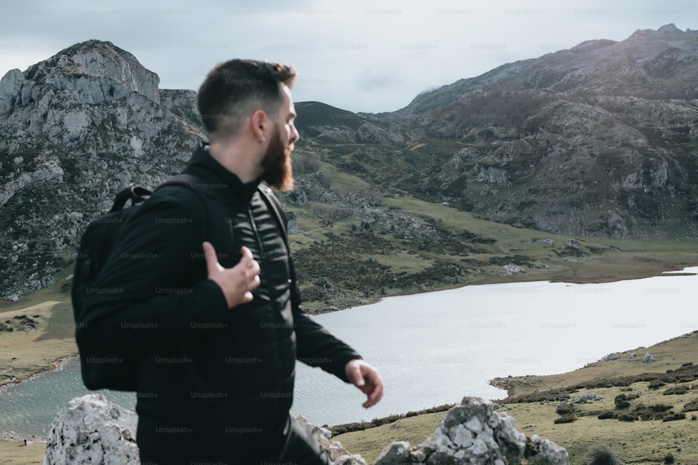 a man with a beard and a backpack on a mountain