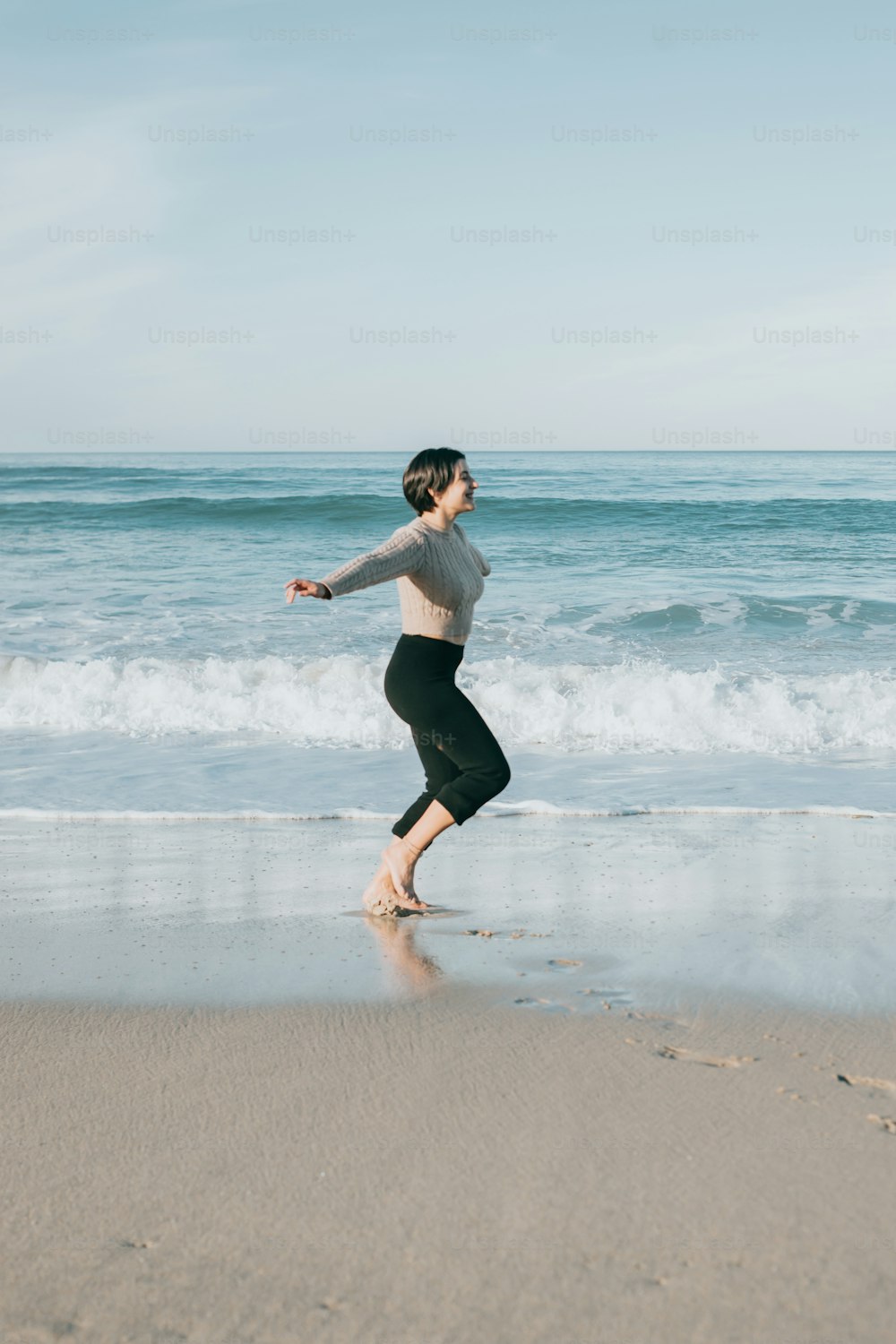 a woman running on the beach near the ocean