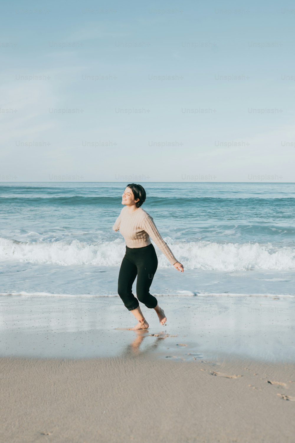 Une femme debout sur une plage au bord de l’océan
