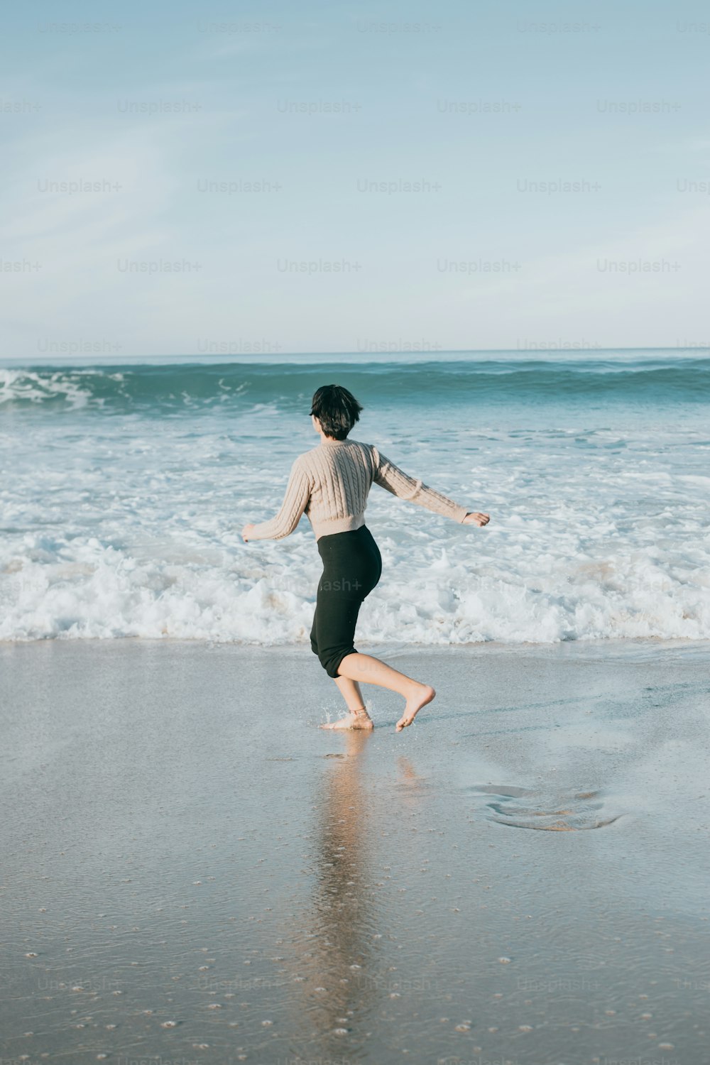 a woman running on the beach near the ocean