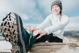 a woman sitting on top of a wooden bench