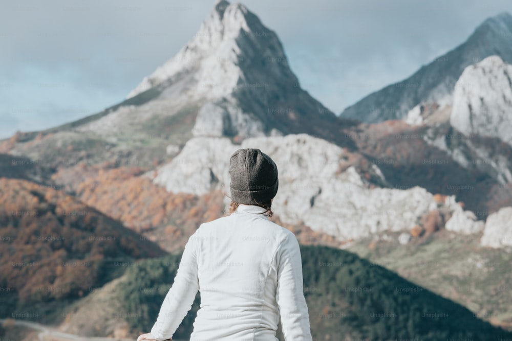 uma pessoa em pé na frente de uma montanha