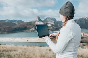 a woman in a beanie using a laptop computer